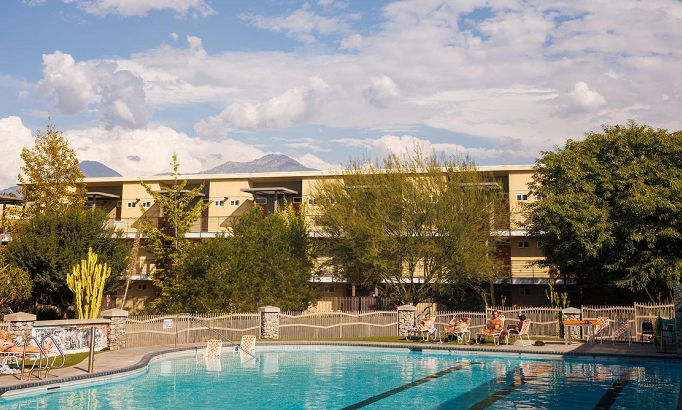 students sit around the gold student center pool